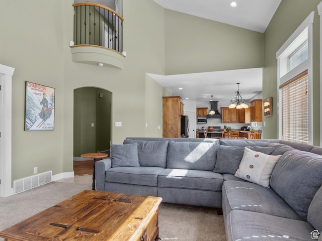 5927 Dartmouth Dr, Mountain Green, UT 84050 - living area with high vaulted ceiling, light colored carpet, arched walkways, and baseboards