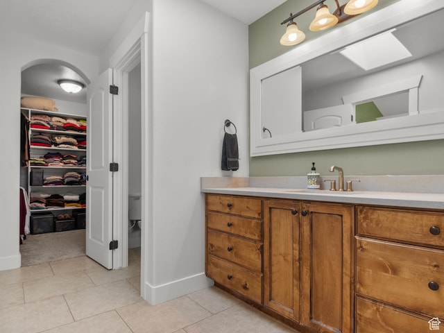 5927 Dartmouth Dr, Mountain Green, UT 84050 - bathroom featuring vanity, baseboards, tile patterned flooring, a walk in closet, and toilet