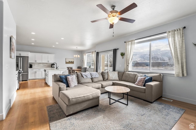 373 S 850 E, American Fork, UT 84003 - living area with baseboards, plenty of natural light, ceiling fan with notable chandelier, and light wood finished floors