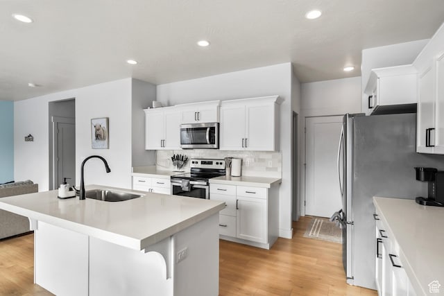 373 S 850 E, American Fork, UT 84003 - kitchen with light wood-type flooring, a kitchen island with sink, a sink, tasteful backsplash, and appliances with stainless steel finishes