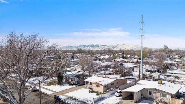 snowy aerial view featuring a residential view and a mountain view