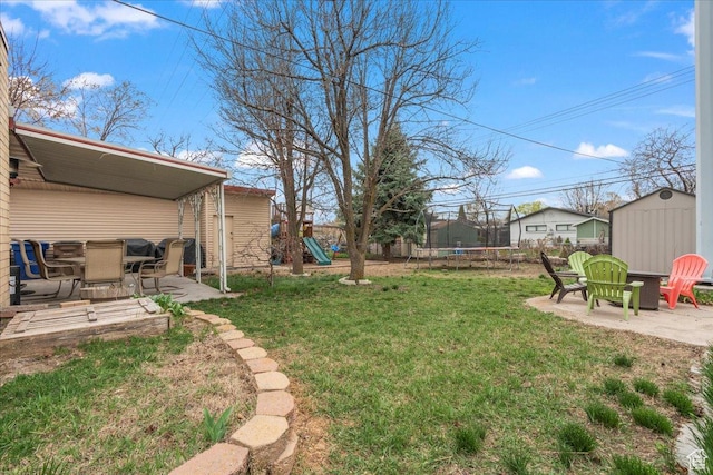 view of yard with a trampoline, a patio, a shed, and a playground