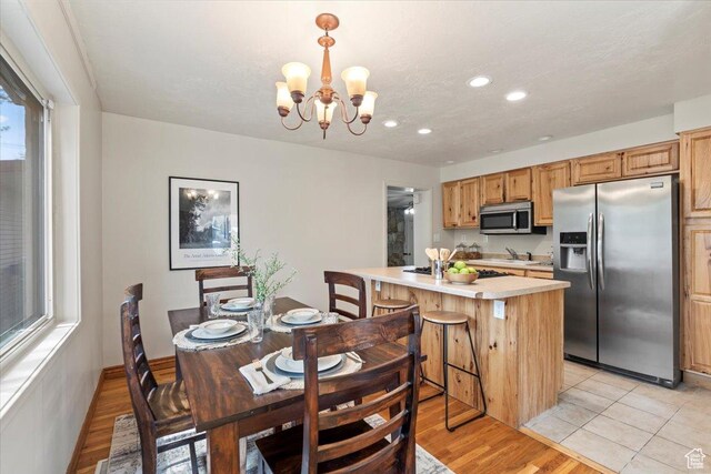 dining area with a notable chandelier, light wood finished floors, and recessed lighting
