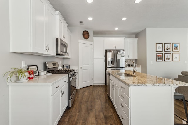 280 S 675 W, Centerville, UT 84014 - kitchen with appliances with stainless steel finishes, a breakfast bar, recessed lighting, white cabinetry, and dark wood-style flooring