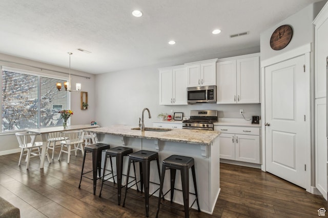 280 S 675 W, Centerville, UT 84014 - kitchen featuring stainless steel appliances, a center island with sink, recessed lighting, white cabinetry, and a kitchen breakfast bar