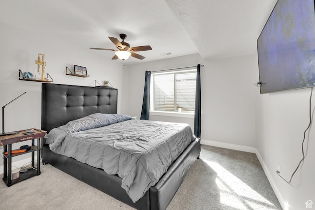 carpeted bedroom with ceiling fan and baseboards