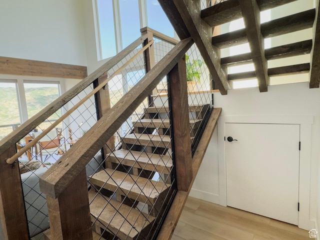 203 Valleyview, Coalville, UT 84017 - staircase featuring wood finished floors, healthy amount of natural light, beam ceiling, and a towering ceiling