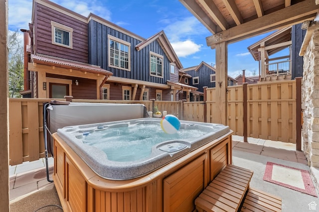 view of patio / terrace with fence and a hot tub