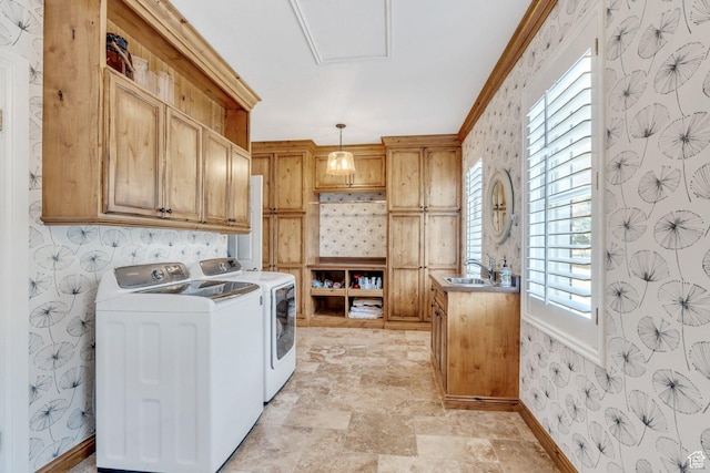 washroom with a sink, cabinet space, separate washer and dryer, and wallpapered walls