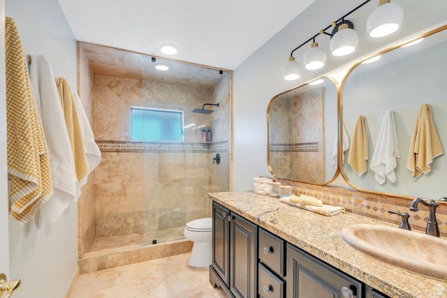 bathroom featuring tiled shower, toilet, and vanity