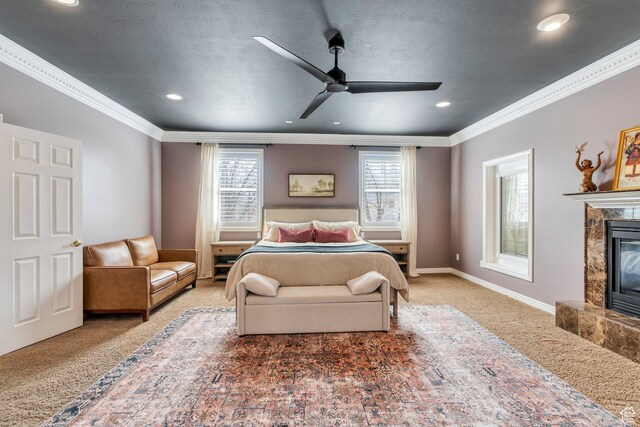 carpeted bedroom with a textured ceiling, crown molding, baseboards, and a premium fireplace