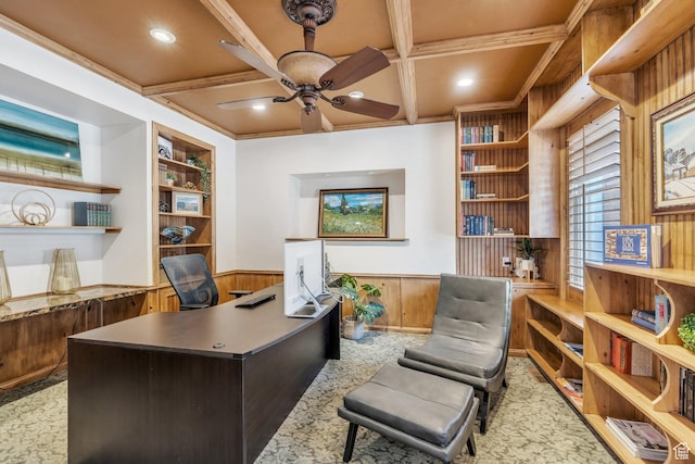 home office with built in shelves, a ceiling fan, a wainscoted wall, coffered ceiling, and beamed ceiling