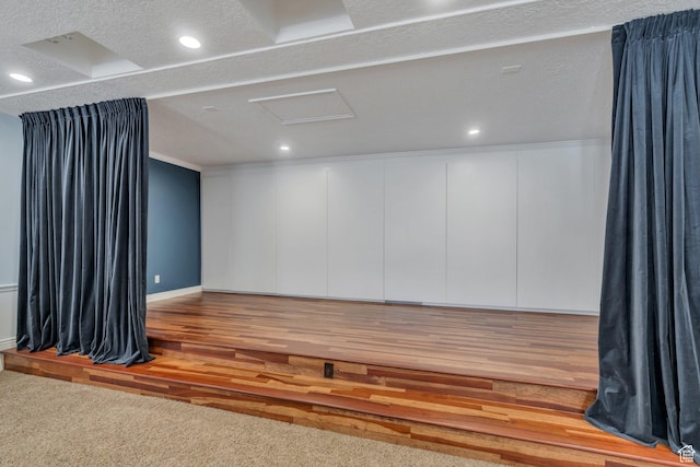 unfurnished room featuring attic access, wood finished floors, crown molding, and recessed lighting