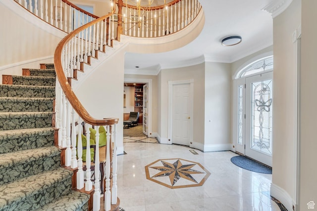 foyer featuring baseboards, ornamental molding, stairs, a notable chandelier, and marble finish floor