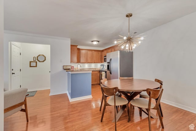 dining space with a notable chandelier, baseboards, light wood-type flooring, and ornamental molding