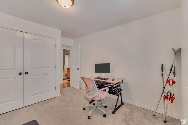 office with baseboards and light carpet