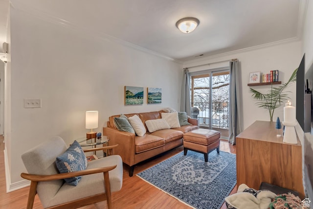 living room with light wood-style flooring and crown molding