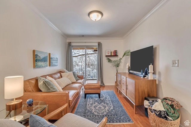 living area with visible vents, light wood-style flooring, and crown molding