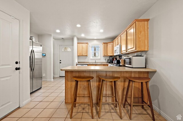 422 N Hodges Ln, Salt Lake City, UT 84116 - kitchen featuring a peninsula, white microwave, stainless steel refrigerator with ice dispenser, and baseboards
