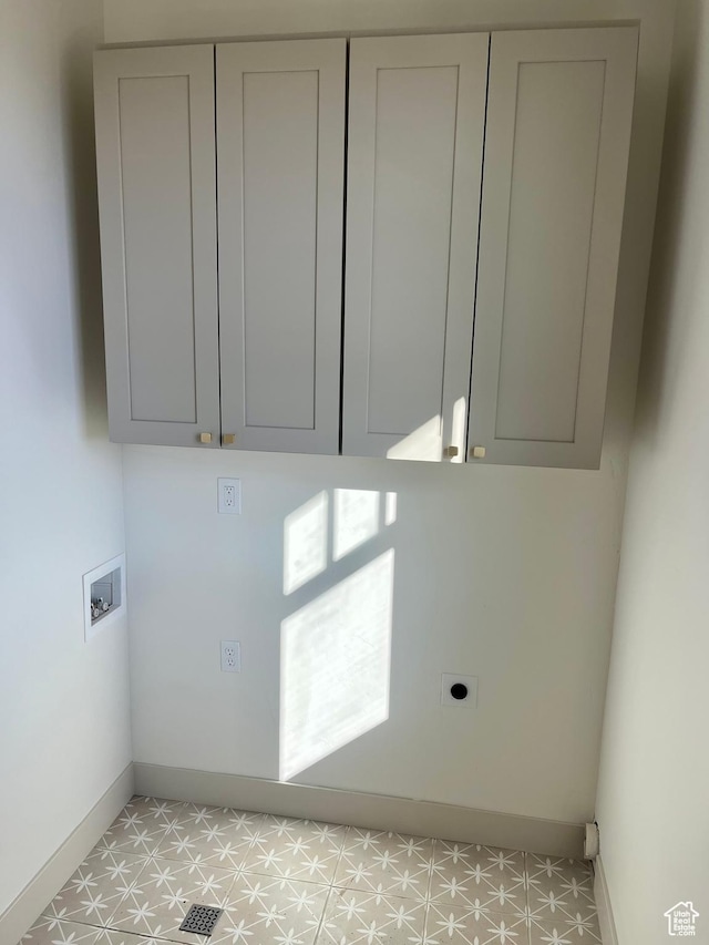 laundry area with electric dryer hookup, cabinet space, light floors, baseboards, and hookup for a washing machine