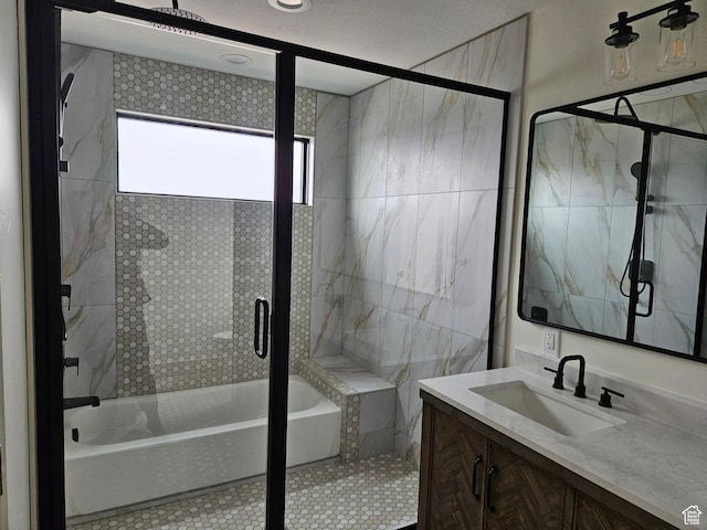 bathroom with an enclosed shower, a bathtub, and vanity