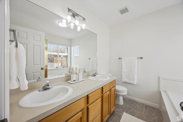 696 W 1275 N, Farmington, UT 84025 - bathroom featuring double vanity, a tub to relax in, toilet, baseboards, and tile patterned flooring