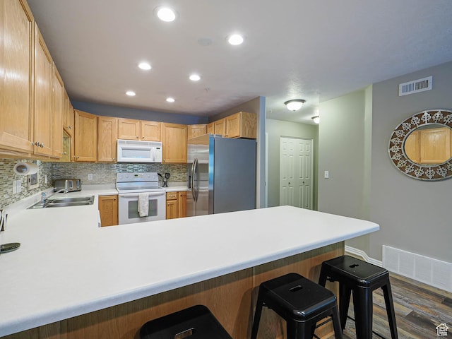 1230 E Privet Dr Unit 214, Salt Lake City, UT 84121 - kitchen featuring white appliances, a peninsula, backsplash, recessed lighting, and light countertops