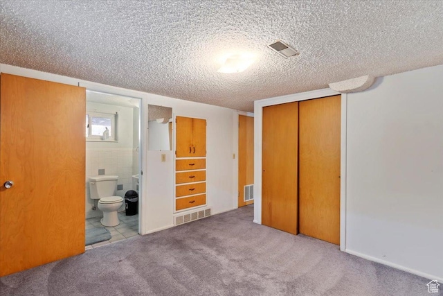 unfurnished bedroom featuring visible vents, a textured ceiling, and a closet