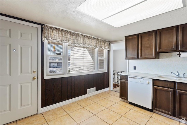kitchen with visible vents, white dishwasher, dark brown cabinets, light countertops, and a sink