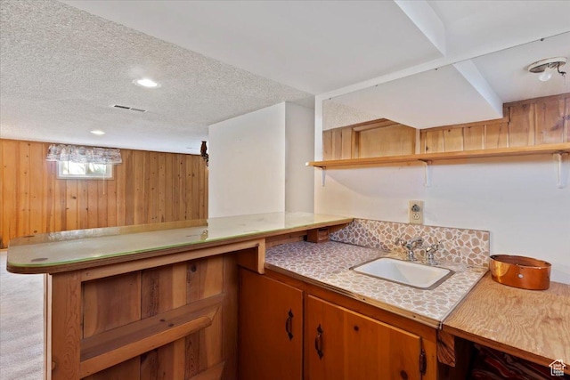 bar featuring visible vents, wooden walls, recessed lighting, a textured ceiling, and a sink