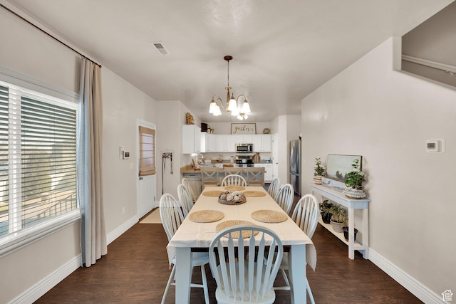 8813 S Bornite Rd, West Jordan, UT 84081 - dining space with dark wood-type flooring, visible vents, baseboards, and a notable chandelier