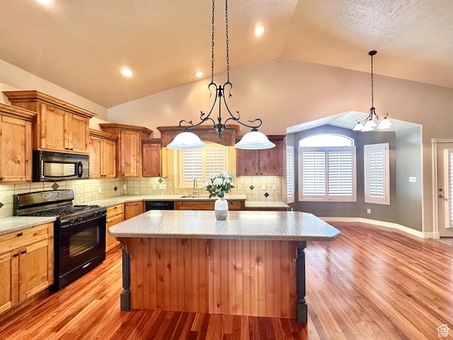 3427 N 2500 W, Farr West, UT 84404 - kitchen featuring light wood finished floors, a kitchen island, black appliances, and decorative light fixtures