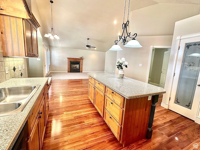 3427 N 2500 W, Farr West, UT 84404 - kitchen featuring vaulted ceiling, light wood-style flooring, a fireplace, a ceiling fan, and a sink