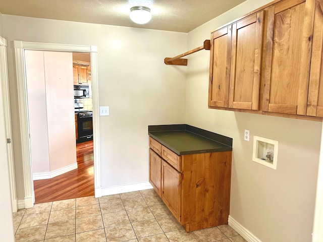 3427 N 2500 W, Farr West, UT 84404 - laundry room featuring light tile patterned floors, cabinet space, baseboards, and washer hookup
