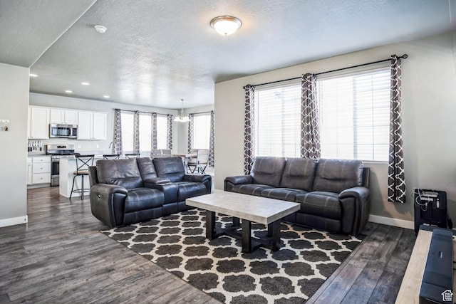 5731 W Osprey Dr, Stansbury Park, UT 84074 - living room featuring dark wood-style floors, a textured ceiling, baseboards, and recessed lighting
