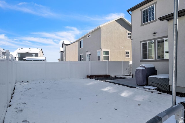 5731 W Osprey Dr, Stansbury Park, UT 84074 - yard covered in snow with a fenced backyard and a patio area