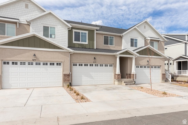 view of front of home featuring stucco siding, an attached garage, driveway, and board and batten siding