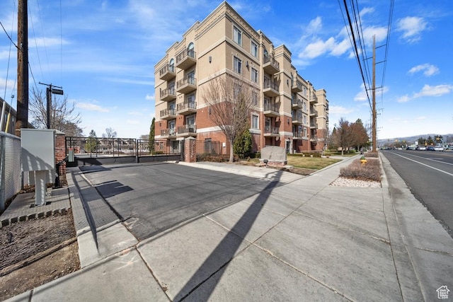 view of street with a gate, curbs, and sidewalks