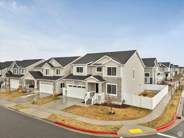 4089 W 1700 N Unit 618, Lehi, UT 84043 - view of front of home with fence, concrete driveway, a garage, stone siding, and a residential view