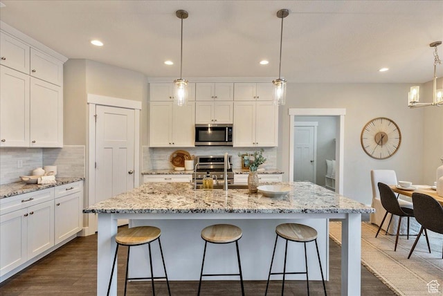 4089 W 1700 N Unit 618, Lehi, UT 84043 - kitchen featuring white cabinetry, dark wood-style floors, a kitchen bar, and stainless steel appliances