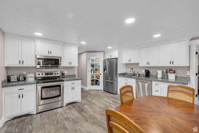 1411 E Elm Leaf Cv, Salt Lake City, UT 84117 - kitchen with white cabinetry, recessed lighting, light wood-type flooring, and appliances with stainless steel finishes