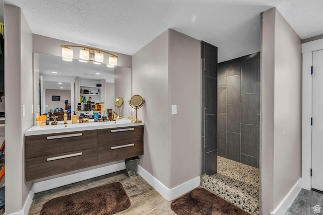 1411 E Elm Leaf Cv, Salt Lake City, UT 84117 - bathroom with a textured ceiling, wood finished floors, vanity, and a walk in shower