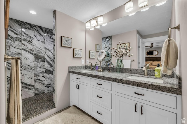 1411 E Elm Leaf Cv, Salt Lake City, UT 84117 - bathroom featuring a sink, tiled shower, a textured ceiling, and double vanity