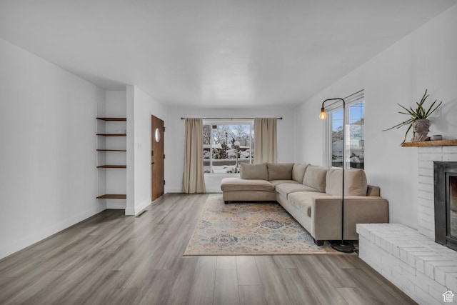 unfurnished living room featuring a healthy amount of sunlight, wood finished floors, and a fireplace