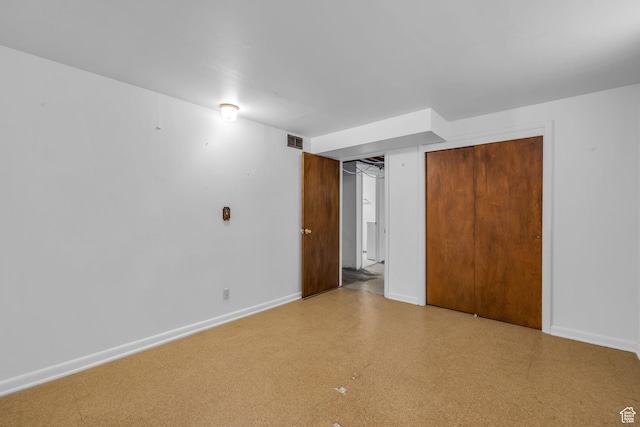 unfurnished bedroom with tile patterned floors, visible vents, baseboards, and a closet