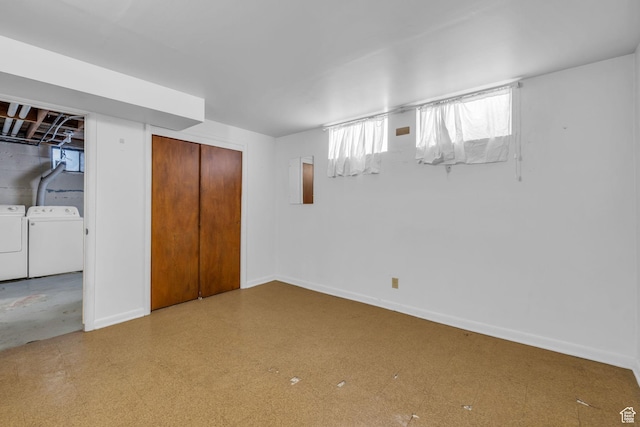 below grade area with tile patterned floors, independent washer and dryer, and baseboards