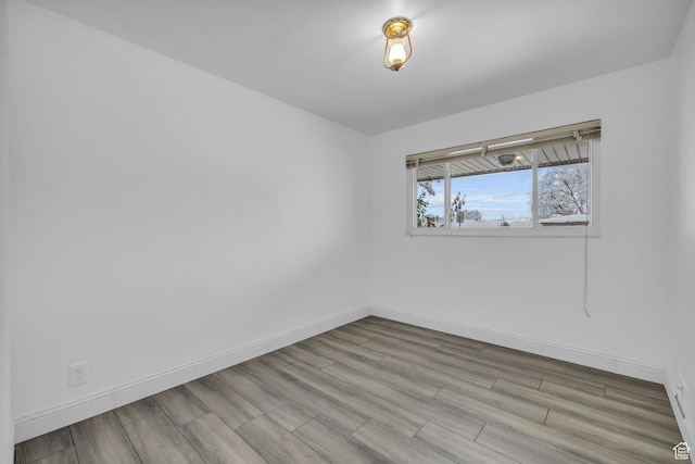 empty room featuring baseboards and wood finished floors