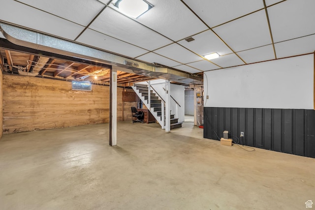 basement with wood walls and stairs