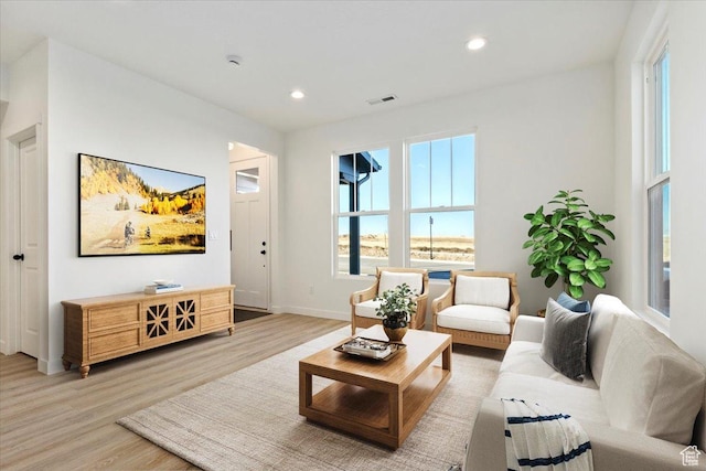 living room featuring light wood-style flooring, recessed lighting, and baseboards