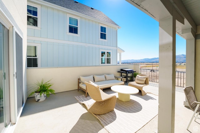 view of patio featuring a mountain view and a balcony
